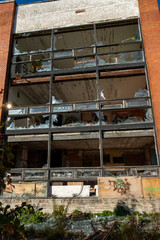 Broken glass in the windows of an old building. Vandals destroy an abandoned high-rise building. Day. Autumn. Russia.