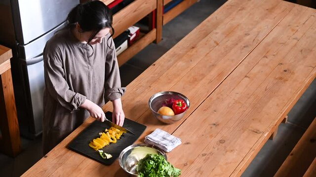 文字を入れて使いやすいキッチンで料理をする日本人女性の俯瞰の動画 コピースペースあり