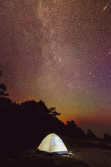 Fototapeta na wymiar tent in the starry night with view of the universe. Camping under the starry sky