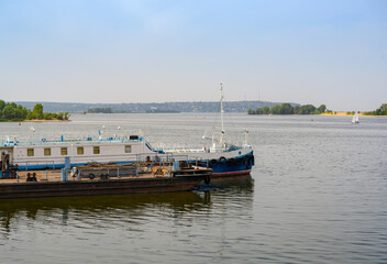 Fototapeta premium The bank of the Volga River with an old barge used as a berth