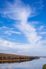 Beautiful, wide river autumn among the woods. Calm and quiet place with autumn colors. In the middle of the river island. View from the top to the distance