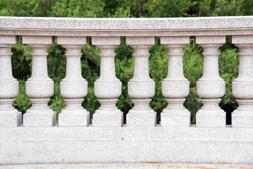 Fototapeta na wymiar Ornate balcony pillars, close up with greenery in background