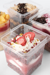 take away trifle cake in a box. red velvet sponge bisquit with mascarpone and berry jam filling. sublimated strawberry and pistachios nuts topping. autumn season sweet treats.