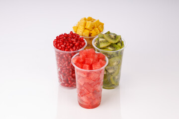 Watermelon , pineapple  , pomegrenate and Kiwi  Slices arranged  in two transparent glasses with white background, isolated