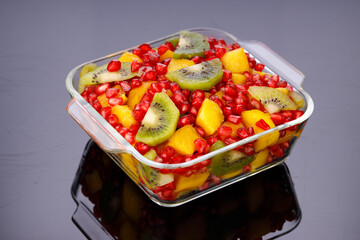 Mixed cut fruits arranged in a transparent tableware , isolated.