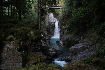 A waterfall flowing underneath a bridge