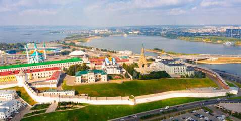Aerial view of large Russian city of Kazan with embankment along Volga river and ancient walled Kremlin on green hill in summer, Tatarstan .