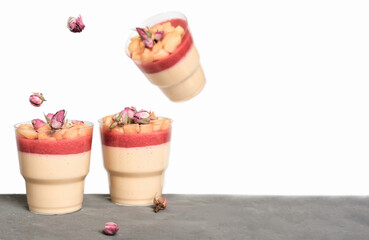 Obraz na płótnie Canvas levitating food. apple mousse with strawberry filling and apple slices decorated with rose buds. autumn comfort food. take away desserts.