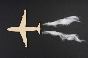 The plane flies and leaves behind traces of emissions. Isolated on black background.