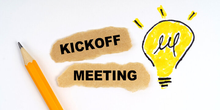 A lamp is drawn on a white sheet, there is a pencil and scraps of paper on which it is written - Kickoff Meeting