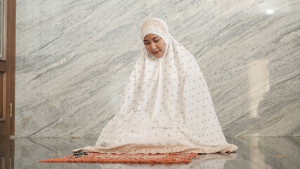 Asian Muslim woman praying in the mosque