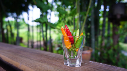 Fresh chili in a glass placed on a wooden plate prepared to make a spicy dipping sauce.