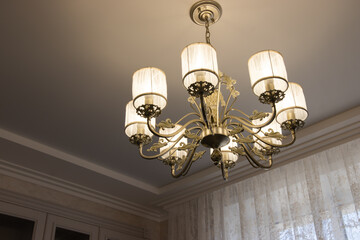 Fototapeta na wymiar chic chandelier in a country house with bulges and contours. beautiful lamp on the ceiling