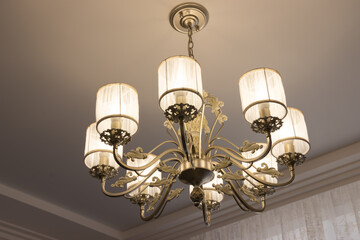 Fototapeta na wymiar beautiful chandelier with bulges and contours in a large house, modern lamps