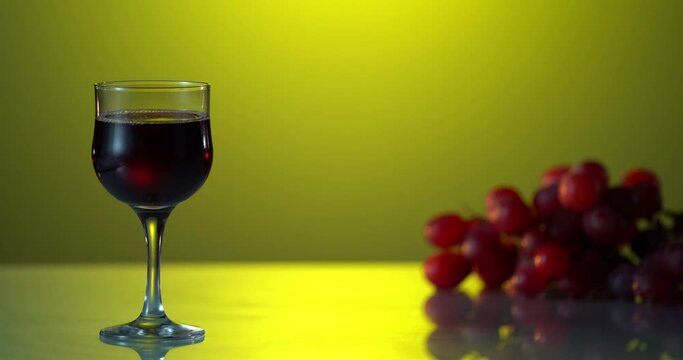 Red wine in glass on colorful background. Advertising shot. Fresh grape in the table. Yellow background. 2 glasses vith tasty alcohol on the table. Holiday shot. Advt