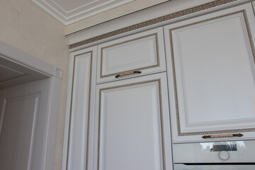 kitchen set with carvings on the facades and carved inserts in white with gray patina