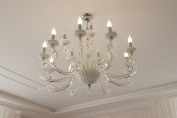 chandelier in a modern style with glowing bulbs contours and curves for a large house