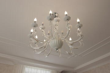 chic chandelier in a country house with bulges and contours. beautiful lamp on the ceiling