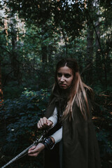 girl in a historical dress in a coniferous forest