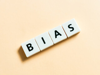 Word BIAS made from square letters against yellow background.
