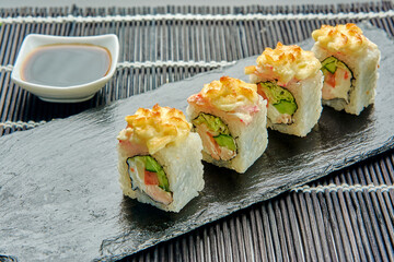 delicious baked rolls with cheese, chicken, tomato, cabbage on a stone stand, sushi