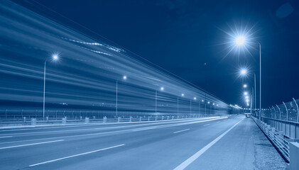 Highway car light trails at night - Asphalt highway and electric poles at night