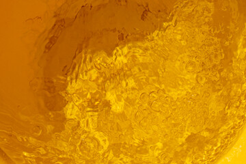 blurred yellow abstract background of reflection of running water with bubbles, top view, horizontal