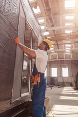 Naklejka na ściany i meble Male builder installing sliding glass door at constriction site
