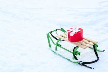 Sledge with gift box on snowy day