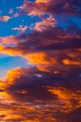 Naklejka na ściany i meble Dramatic orange clouds at sunset. Cloudscape abstract background photo.