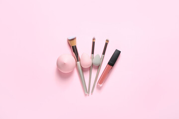 Obraz na płótnie Canvas Stylish makeup sponges, lipstick and brushes on color background