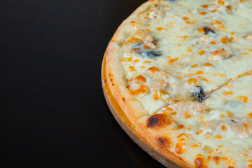 Slice of chicken pizza with cheese and corn pieces on a black background