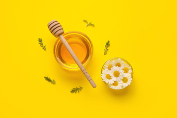 Composition with bowls of honey and chamomile flowers on color background