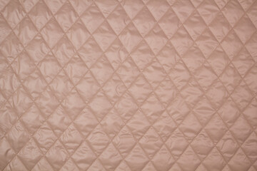 Fototapeta premium Quilted fabric. The texture of the blanket. Beige textiles 