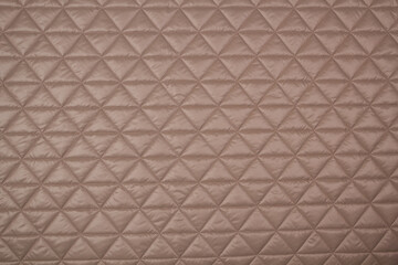 Quilted fabric. The texture of the blanket. Beige textiles	
