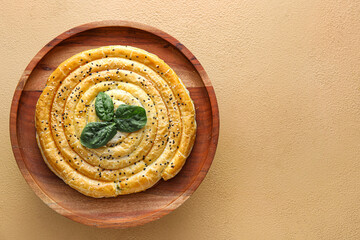 Wooden stand with tasty spinach pie on color background