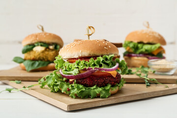 Wooden boards with tasty vegetarian burgers on table