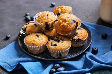 Composition with tasty blueberry muffins and berries on dark background
