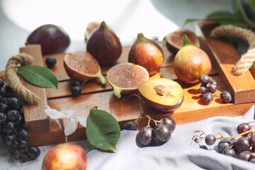 Fruits on the table. Grapes,Fruit platter on the table. Grapes, peaches and figs for breakfast. 
Autumn still life Warm colors. peaches and figs