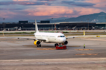 Tractor on the push back maneuver of an airplane in the airport preparing the plane for the take off