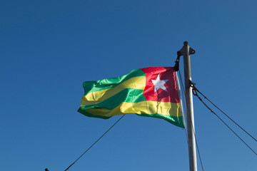 Togo national flag waving against blue sky