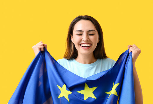 Young woman with flag of European Union on color background