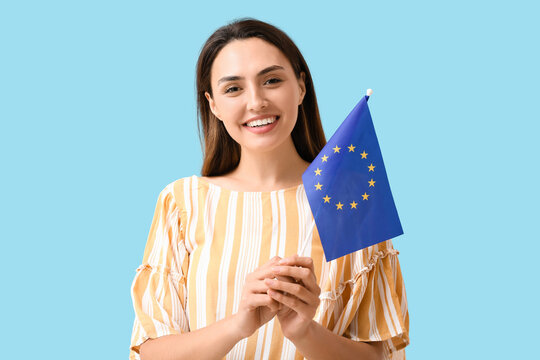 Young woman with flag of European Union on color background