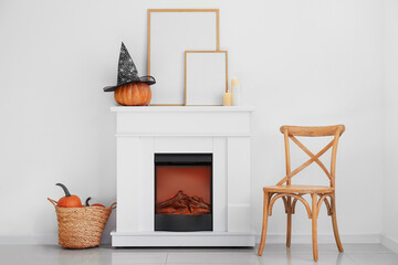 Stylish interior of room with fireplace and chair decorated for Halloween party