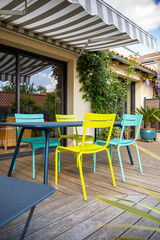 Fototapeta na wymiar Salon de jardin coloré sur une terrasse en bois.