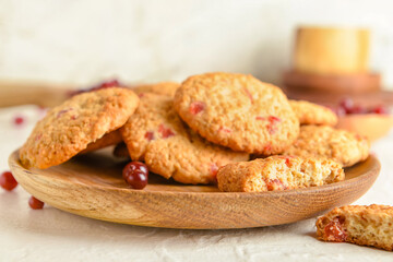 Plate with tasty cranberry cookies on light background