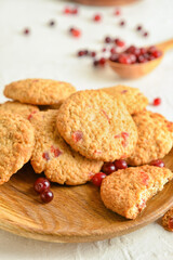 Plate with tasty cranberry cookies on light background, closeup