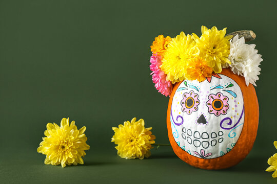 Pumpkin with painted skull on color background. Celebration of Mexico's Day of the Dead (El Dia de Muertos)