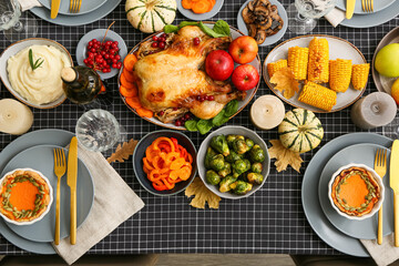 Table setting with roasted turkey, different food and bottle of wine
