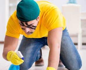 Man in military style cleaning the house